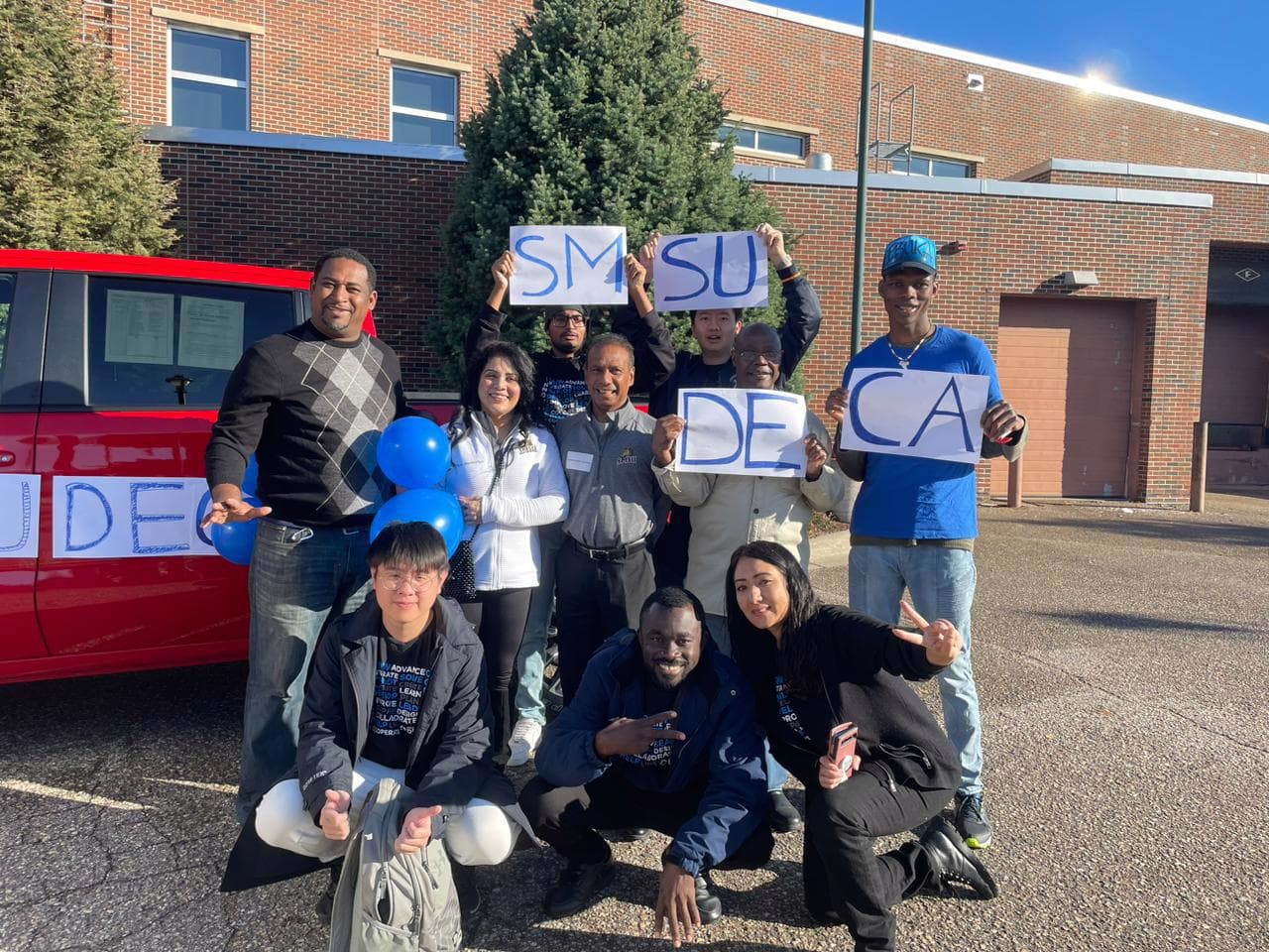 SMSU DECA members holding chapter signs